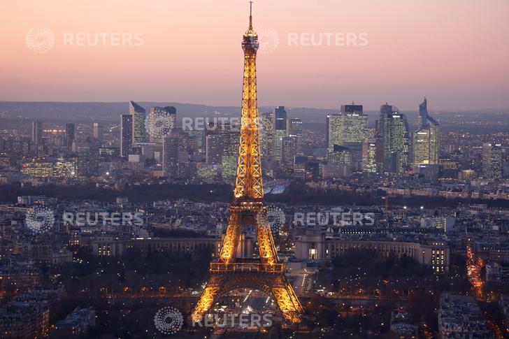 A general view show the illuminated Eiffel Tower and the skyline of La Defense business district (Rear) at night in Paris, France, November 28, 2016. REUTERS/Charles Platiau