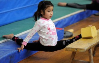 Pequena ginasta chinesa treinando em uma escola em Hefei