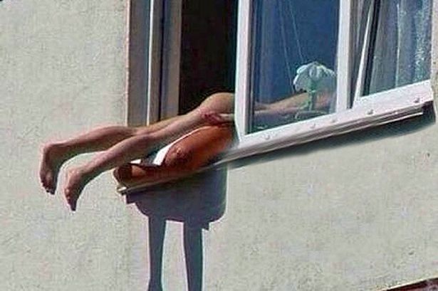 Mulher toma banho de sol nua na janela e causa acidente!